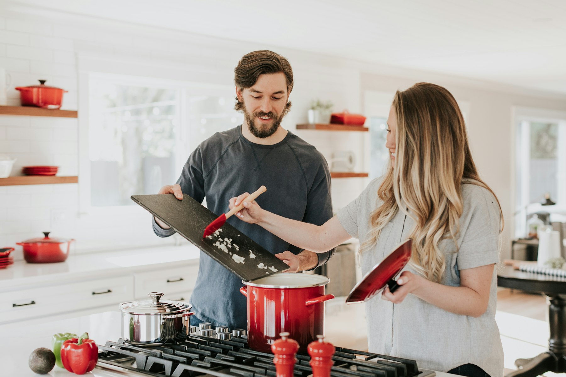 Couple préparant un plat dans une cuisine contemporaine