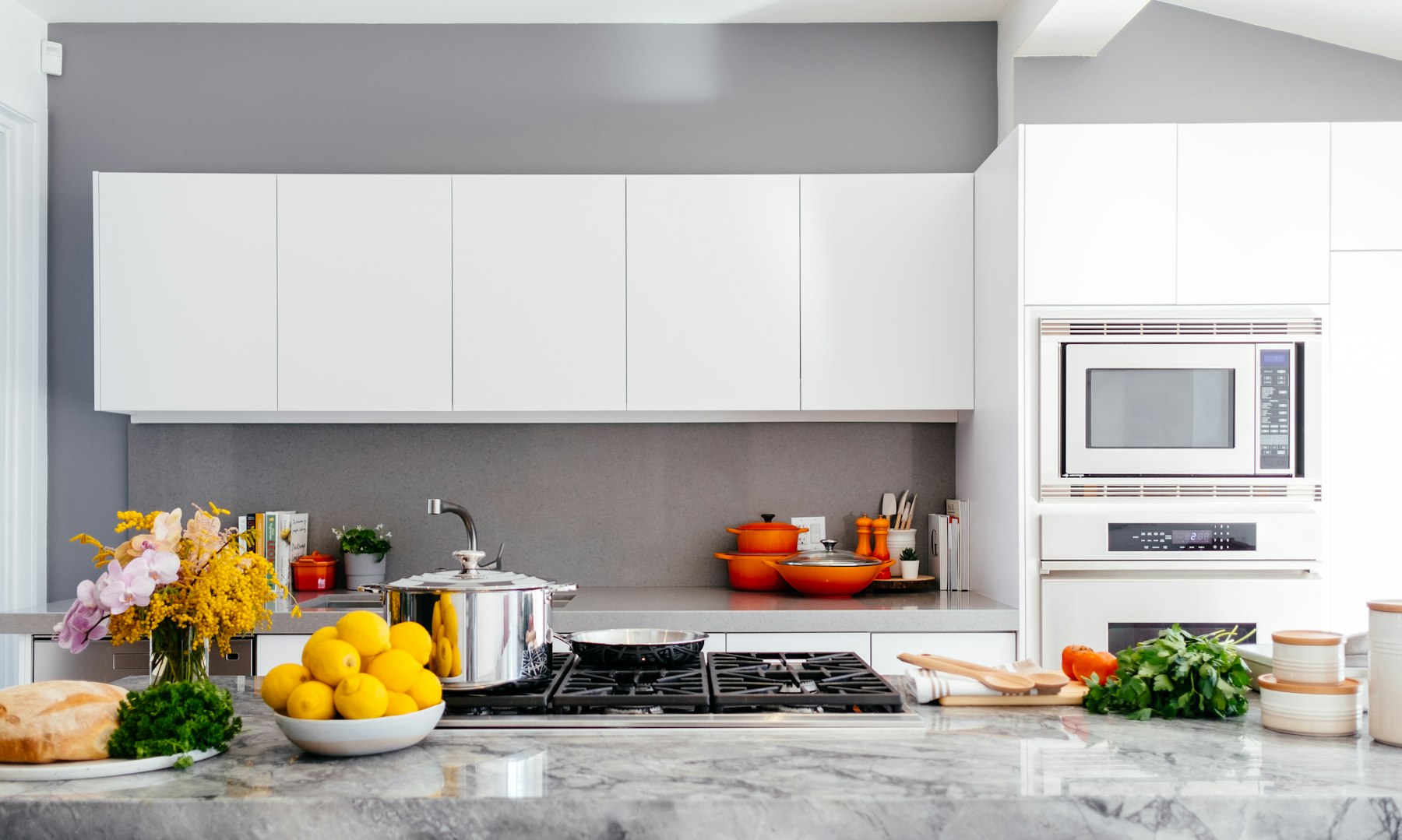 Cuisine blanche contemporaine, îlot marbre et plaques encastrées